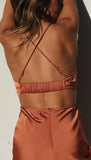 Back view of the rust-colored slip dress showing the strappy detail.