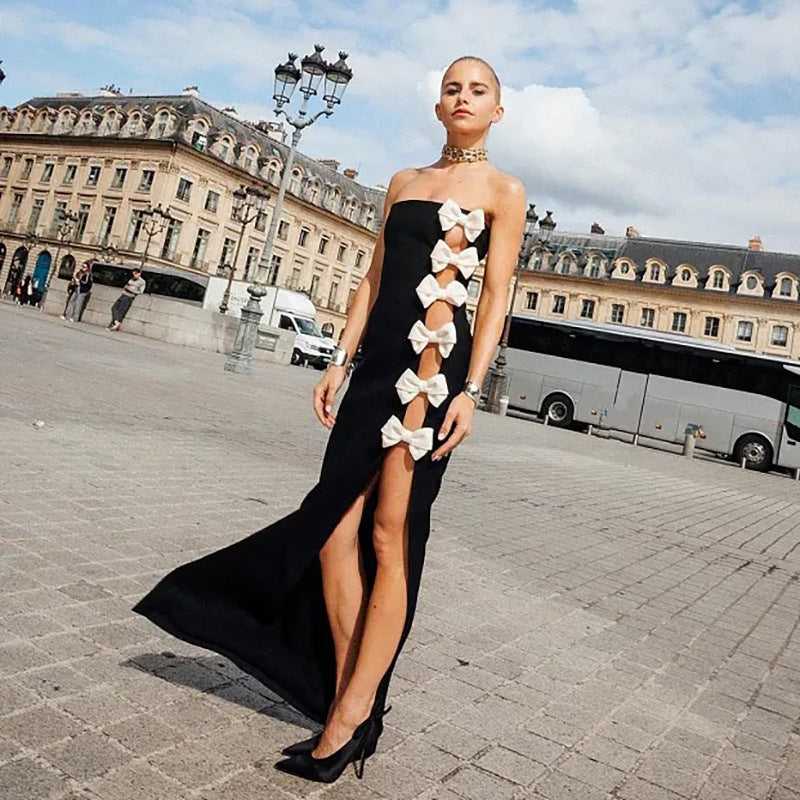 Full body shot of a black formal dress with statement bow details.