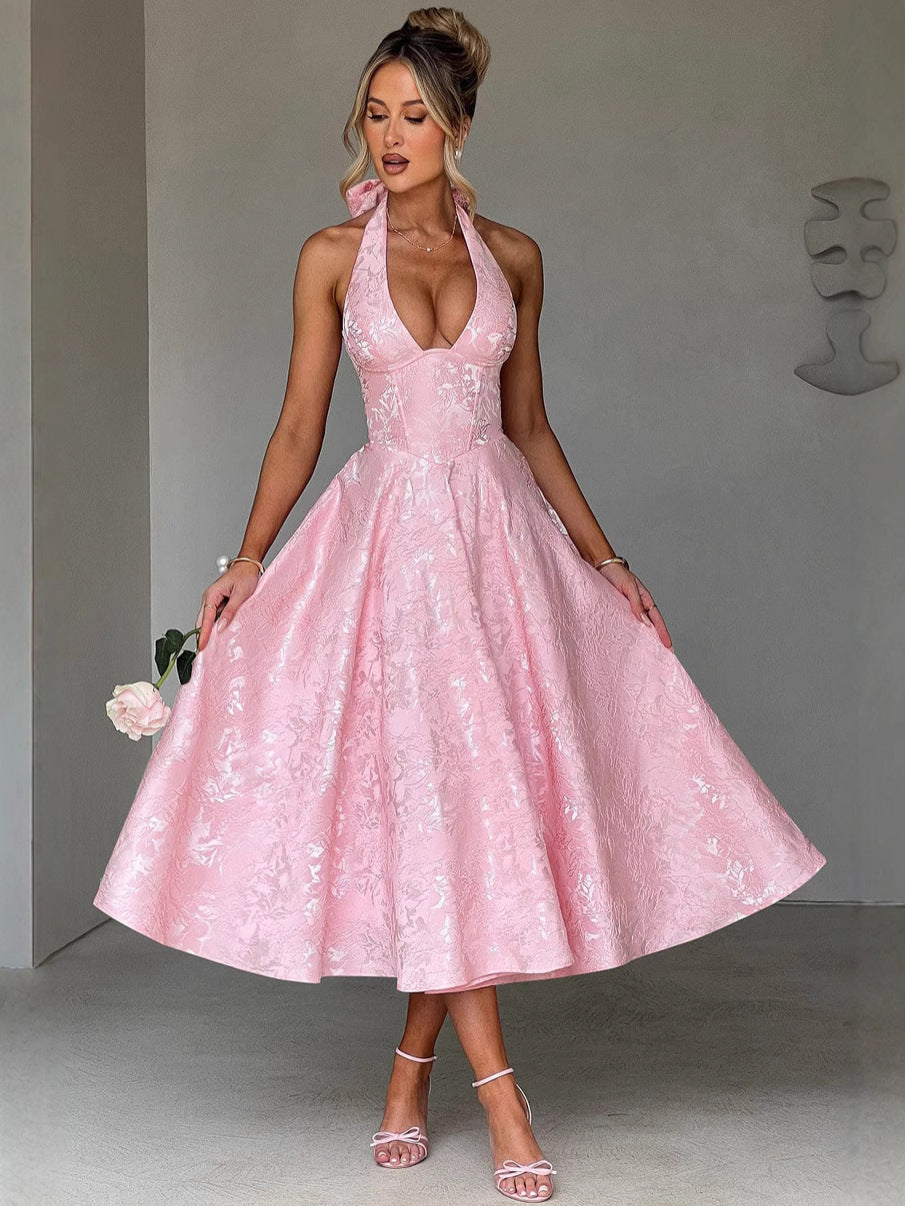 Woman in a pink jacquard halter neck dress with a corset bodice and full A-line skirt.